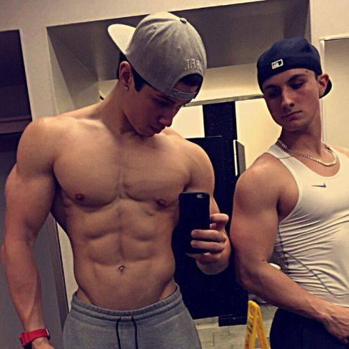 Locker room selfies for the win! The shirtless guy is bigger and the other guy knows it.